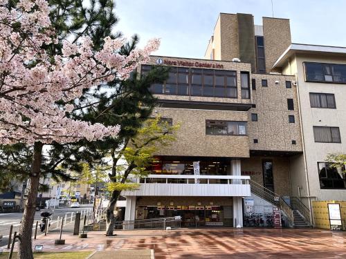 奈良奈良县游客交流馆 & 住宿中心的前面有粉红色花卉的建筑