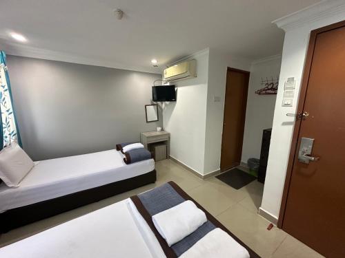 普崇玛哈酒店的一间酒店客房,配有一张床和一台电视