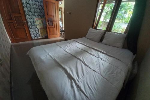 普禾加多OYO 93892 Homestay Koe Syariah的一张带白色床单和枕头的床