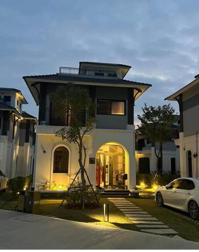 Cái RồngPeony Villa - Sonasea Vân Đồn, Quảng Ninh的停在房子前面的白色汽车