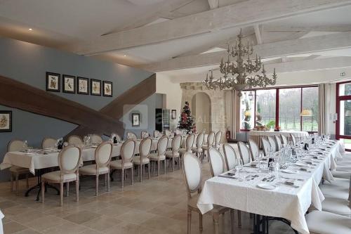 SepmesChateau Laroche-Ploquin的大型用餐室配有白色的桌子和白色的椅子