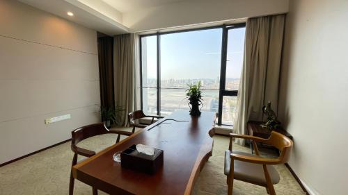 广州星驿国际公寓（广州保利世贸会展中心店）的一间会议室,配有桌椅和大窗户