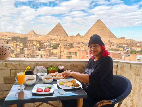 开罗Pyramids station View的坐在餐桌上吃一盘食物的女人