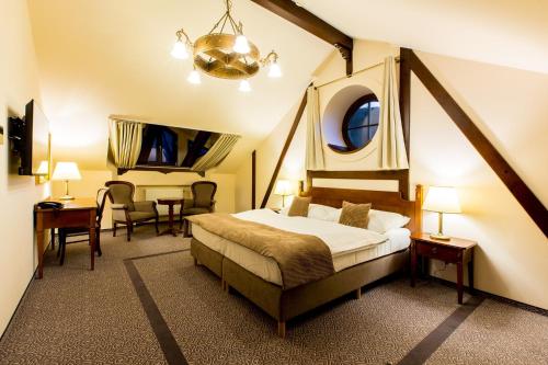 科希策班库夫科希策酒店的卧室配有一张床和一张桌子及椅子