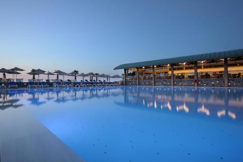库基尼坎尼奥Arina Beach Resort的一个带椅子和遮阳伞的大型水池