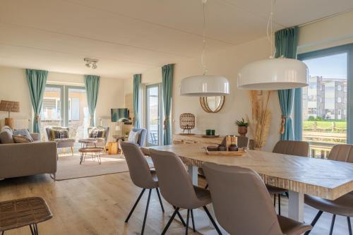 朱丽安娜多普Dormio Villapark Duynzicht的客厅配有大型木桌和椅子