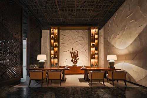 沙努尔Bali Beach Hotel的一间带桌椅和石墙的用餐室
