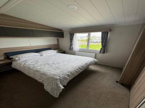 LongniddryLovely 2-Bed Caravan in Prestonpans的一间卧室设有一张床和一个窗口