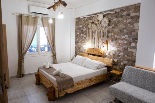 埃尔莫波利斯Onar Syros - Rustic Rooms的一间卧室配有一张床和一把椅子