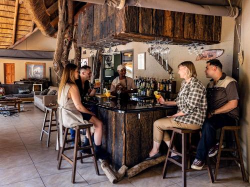 布里茨Sable Ranch Bush Lodge的一群坐在酒吧里的人