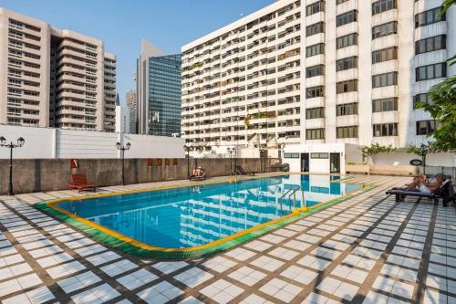 曼谷1 BedRoom Omni Tower Bangkok center Near Ploenchit Asoke Sukhumvit BTS Night Club Pool&Gym的一座位于高楼城市的游泳池