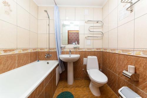 阿斯塔纳O Azamat的浴室配有卫生间、盥洗盆和浴缸。