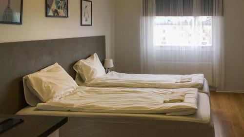 松兹瓦尔Liz Motell的卧室内的两张床,配有白色床单和枕头