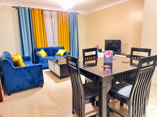 NamugongoKamona Living的客厅配有桌椅和沙发