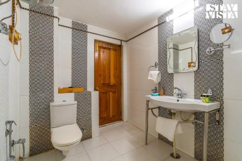 马拉里StayVista at The Manor的一间带卫生间、水槽和镜子的浴室