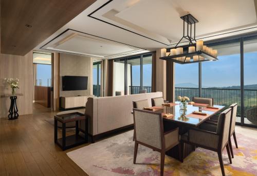 茂物皇家郁金香古南格丽斯高尔夫酒店的用餐室以及带桌椅的起居室。