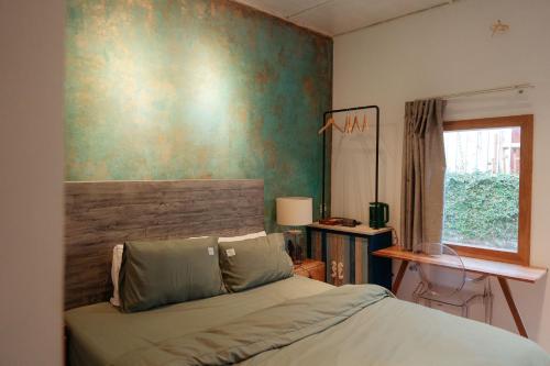 邦美蜀House Of Lens的一间卧室设有一张床和绿色的墙壁