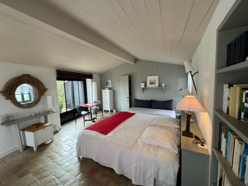 圣克莱门特德巴Ma Chambre d'Amis的一间卧室配有一张带红色毯子的床