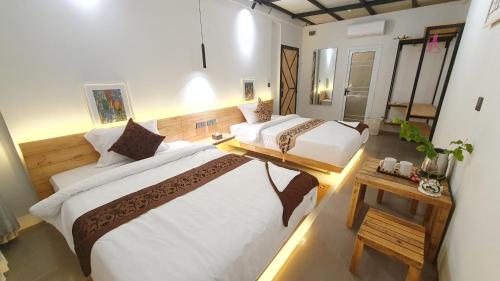 西哈努克Cool Home Office, Sihanoukville的一间大卧室,配有两张床和一张桌子