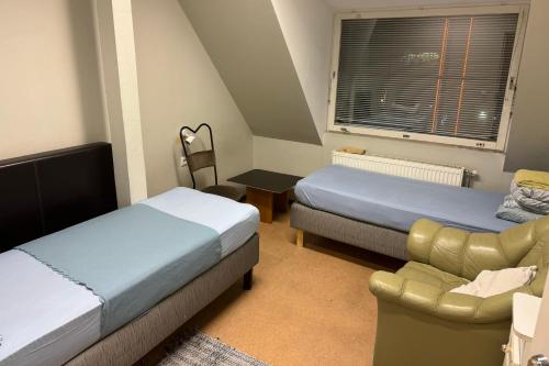 塔林Rotermanni hostel 4Floor NO LIFT的一间卧室配有两张床、一张沙发和一把椅子