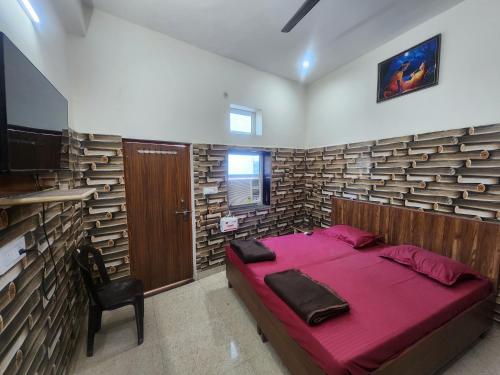 范兰德凡Radha Rani Dham (Near Iskcon Temple)的一间卧室配有一张床和一把椅子