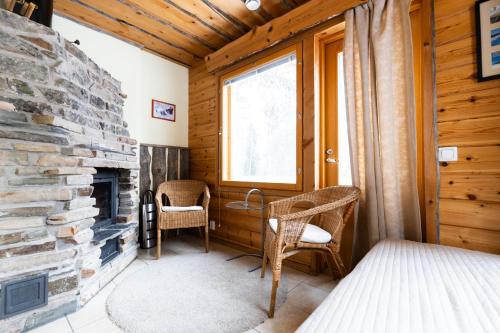 普哈圣山Pyhäkoti Holiday Home的一间设有石制壁炉和藤椅的客房