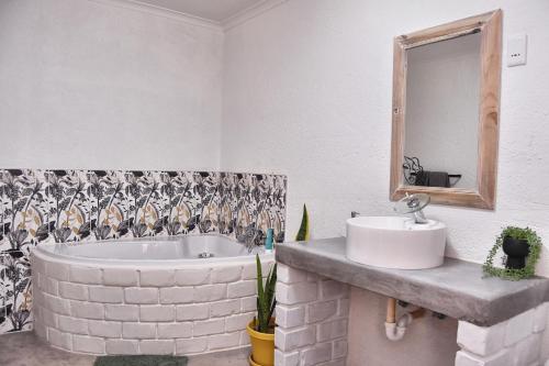 奥马鲁鲁Knowhere Selfcatering Unit 2的带浴缸、水槽和镜子的浴室