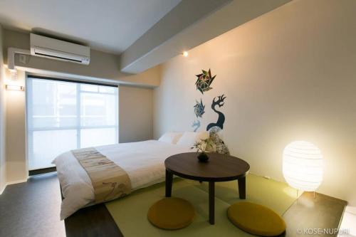 广岛bHOTEL Origaminn 403 - 5 mins PeacePark的一间卧室配有一张大床和一张桌子