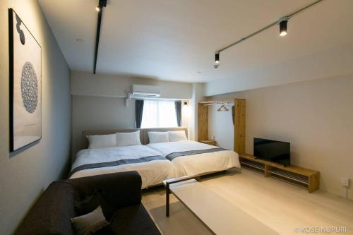 广岛bHOTEL Origaminn 502 - 5 mins PeacePark的一间卧室配有一张大床和一张沙发