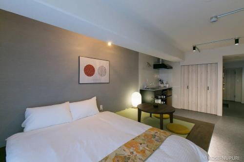 广岛bHOTEL Origaminn 503 - 5 mins PeacePark的一间带白色床的卧室和一间厨房