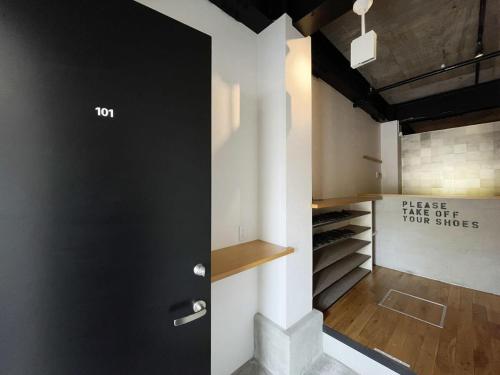 廿日市bHOTEL Kaniwasou 101 1BR good for 8PPL in the scenic Island of Miyajima的一间设有黑色门和步入式衣柜的房间