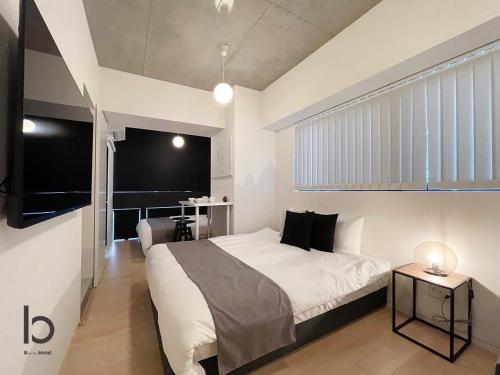 广岛bHOTEL Nekoyard - 1BR Apartment, Good for 6 Ppl, Near Peace Park, WIFI Available的卧室配有一张白色的大床和一张桌子