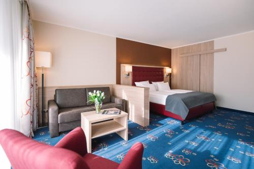 蒂门多弗施特兰德皇家酒店的酒店客房,配有床和沙发