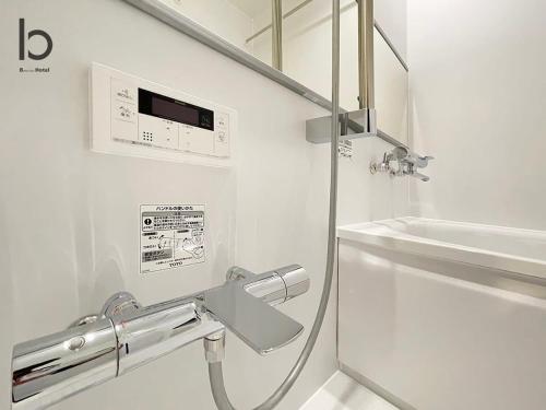 广岛bHOTEL Nekoyard - Modern new 1BR apt very close to peace park room wifi 7ppl的带淋浴和盥洗盆的白色浴室
