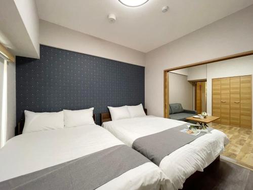 广岛bHOTEL Casaen - 1BR Apartment with beautiful City View Near Shopping District For 6Ppl的两张睡床彼此相邻,位于一个房间里