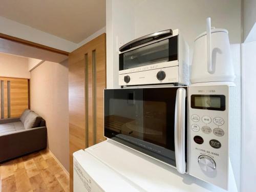 广岛bHOTEL Casaen - 1BR Apartment with beautiful City View Near Shopping District For 6Ppl的厨房的台面上有一个微波炉