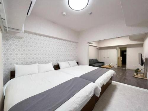 广岛bHOTEL Casaen - Cozy 1BR Apt near Hondori District for 6 Ppl的一间带大床的卧室和一间客厅