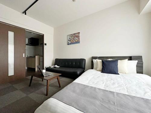 广岛bHOTEL Nagomi - Well-Furnished with balcony Apt for 3 Ppl的酒店客房,配有床和沙发