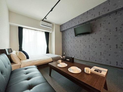 广岛bHOTEL Nagomi - Comfy 1 Bedroom in City Center for 3ppl的带沙发、床和桌子的客房