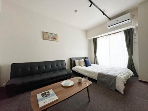 广岛bHOTEL Nagomi - Luxe Apt for 3Ppl City Center的酒店客房,配有床和沙发