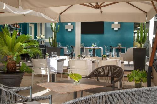 罗马The Guardian的一间带桌椅和蓝色墙壁的餐厅