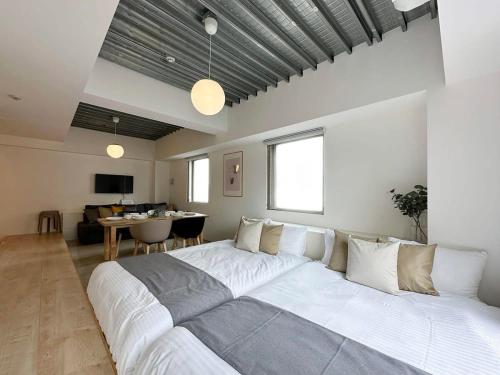 广岛bHOTEL Arts Dobashi - Studio Apt for 6 Ppl Near Peace Park的一张大白色的床,位于带桌子的房间