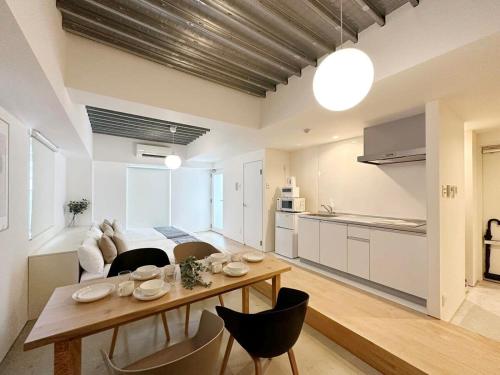 广岛bHOTEL Arts Dobashi - Studio Apt for 6 Ppl Near Peace Park的厨房以及带桌椅的起居室。