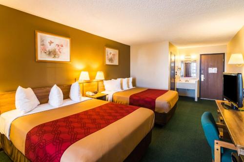 杜马Econo Lodge Dumas的酒店客房配有两张床和一张书桌