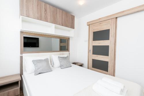 克拉科夫Sunny Kliny Apartment的卧室配有白色的床和窗户。