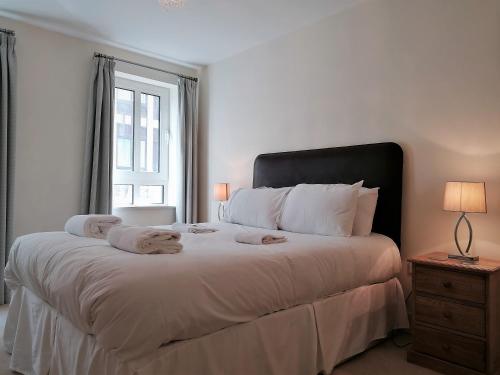伦敦静物塔山高级公寓的白色卧室配有一张大床和毛巾