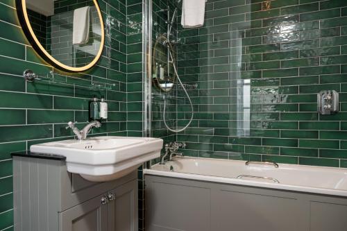 西姆雷Himley House by Chef & Brewer Collection的绿色瓷砖浴室设有水槽和浴缸