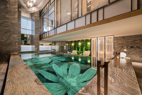 利雅德Narcissus The Royal Hotel的一座种植了绿色植物的室内游泳池