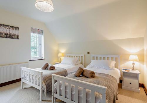伯恩茅斯Throop House Cottage - Bournemouth的一间卧室设有两张床和窗户。