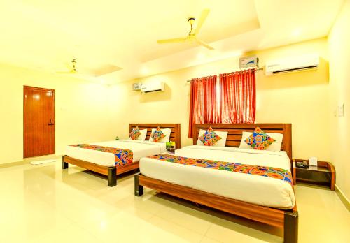 钦奈K HOTELS - CHENNAI AIRPORT的一间卧室设有两张床和窗户。